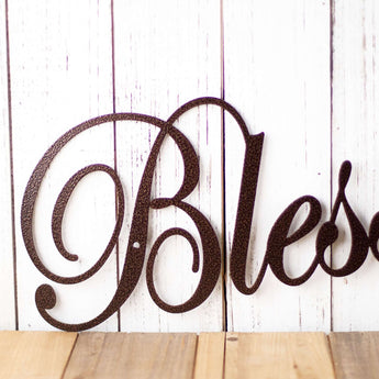 Close up of script lettering on our Blessings metal wall decor, in copper vein powder coat. 