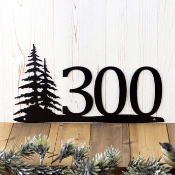 Close up of 3 digit metal house number sign with pine trees, in matte black powder coat. 