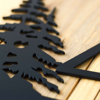Close up of matte black powder coat on our 4 digit metal house number sign with pine trees.