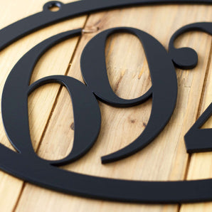 Close up of matte black powder coat from our horizontal oval 4 digit metal house number sign. 