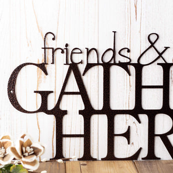 Close up of Friends and Family Gather Here metal wall art, in copper vein powder coat.