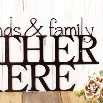 Close up of Friends and Family Gather Here metal wall art, in copper vein powder coat.