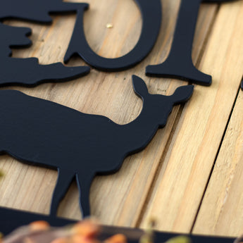 Close up of matte black powder coat on our custom family name metal sign with doe deer silhouette.