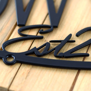 Close up of matte black powder coat on our oval personalized family name sign. 