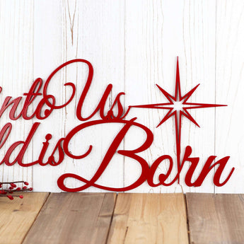 Close up of Unto Us a Child is Born metal wall art, in red gloss powder coat.