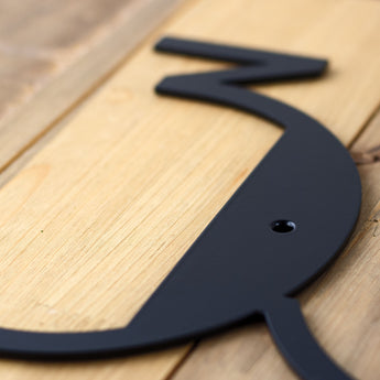 Close up of matte black powder coat on modern metal house number sign.