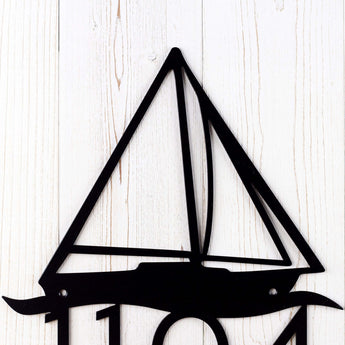Close up of sailboat silhouette on our metal house number sign, in matte black powder coat. 
