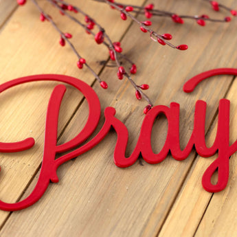 Close up of Pray on our Eat Pray Love metal wall art, in red gloss powder coat.