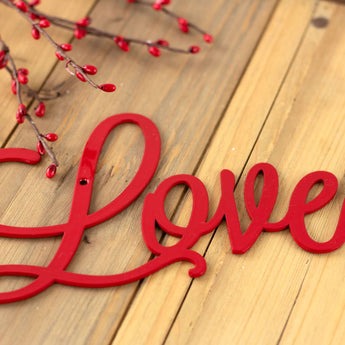 Close up of Love on our Eat Pray Love metal wall art, in red gloss powder coat.