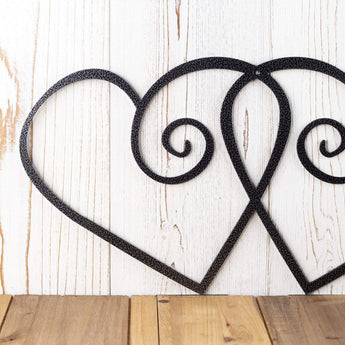 Close up of curly hearts metal wall art, in silver vein powder coat. 