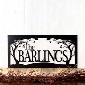 Rectangular metal family name sign with cherry trees, in matte black powder coat. 