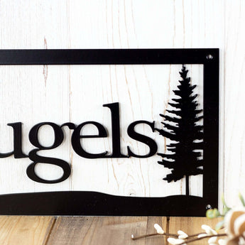 Close up of pine tree silhouette on our custom family name sign, in matte black powder coat.