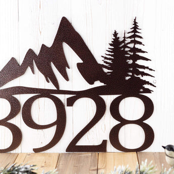 Close up of pine trees on our 4 digit metal house number sign, in copper vein powder coat.