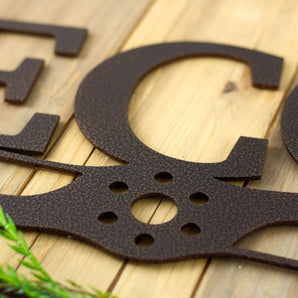 Close up of pilot family name metal sign with propeller, in copper vein powder coat. 