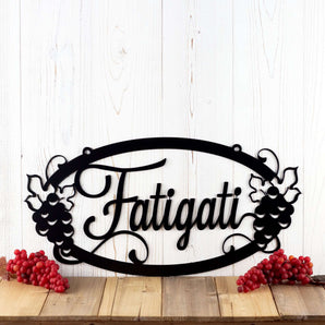 Oval personalized name metal sign with grapevines, in script lettering. 