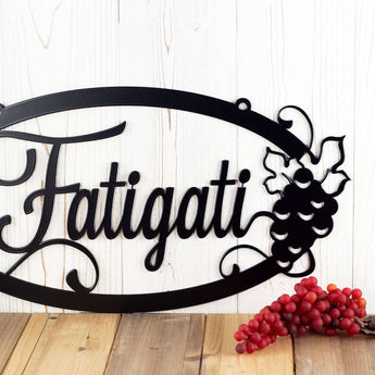 Close up of grapes and grapevines on our oval custom metal sign, in matte black powder coat. 