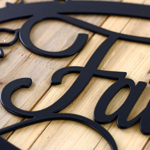 Close up of matte black powder coat on our grapevines custom name oval metal sign.