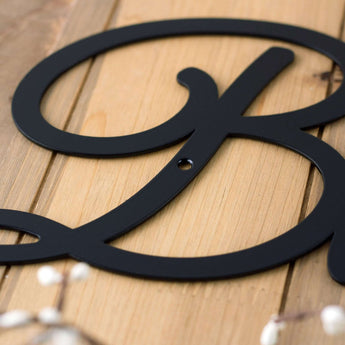 Close up of matte black powder coat on the Bienvenue metal plaque.