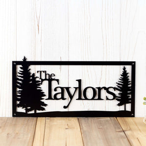 Rectangular personalized family last name sign with pine trees, in matte black powder coat. 