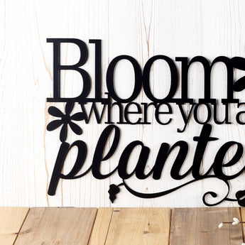 Close up of Bloom where you are planted wording on our metal plaque, in matte black powder coat. 