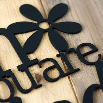 Close up of matte black powder coat on our Bloom where you are Planted metal wall art. 