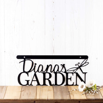 Close up of metal garden hanging sign with first name and dragonfly, in matte black powder coat.