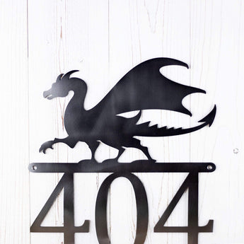 Close up of dragon silhouette on our metal house number sign, in raw steel.