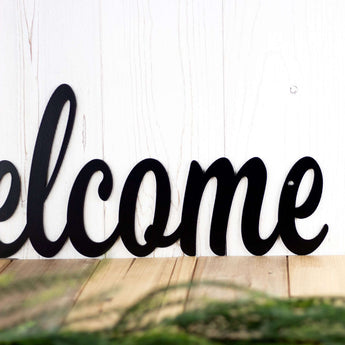 Close up of script lettering on our welcome metal sign, in matte black powder coat. 