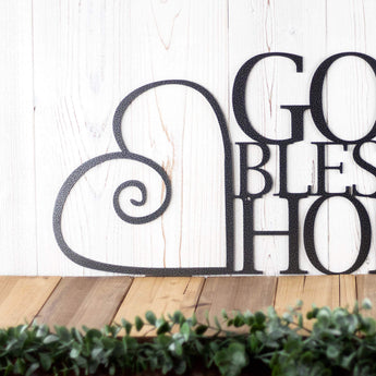 Close up of curly heart on our God Bless Our Home metal sign, in silver vein powder coat. 