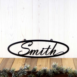 Oval family last name metal sign with script font, in matte black powder coat. 