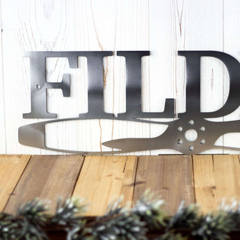 Close up of pilot family name metal sign with propeller, in raw steel. 