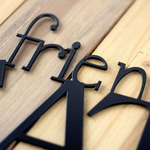 Close up of matte black powder coat on our Friends and Family Gather Here metal sign.