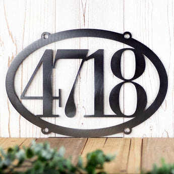 Horizontal oval 4 digit metal house number plaque, in raw steel.