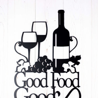 Close up of wine bottle, wine glasses and grapes on our Good Food Good Wine Good Friends metal sign, in matte black powder coat.