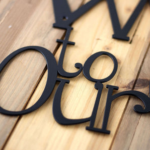 Close up of matte black powder coat on our Welcome to our cottage metal wall decor. 