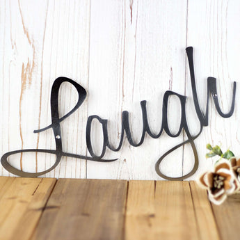 Close up of Laugh script word sign on our Live Laugh Love metal wall art, in raw steel. 