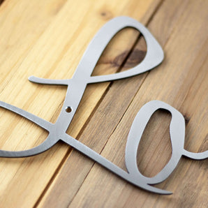 Close up of raw steel on our Live Laugh Love script metal signs.