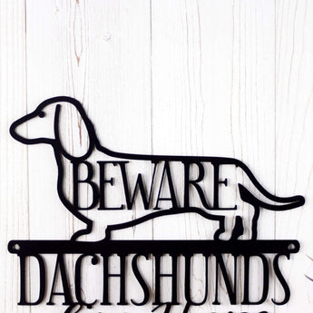 Close up of Dachshund dog silhouette on our Dachshunds Live Here metal sign, with Beware, in matte black powder coat. 