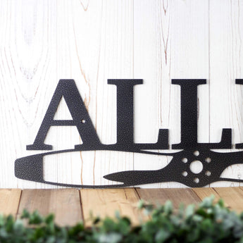 Close up of pilot family name metal sign with propeller, in silver vein powder coat. 