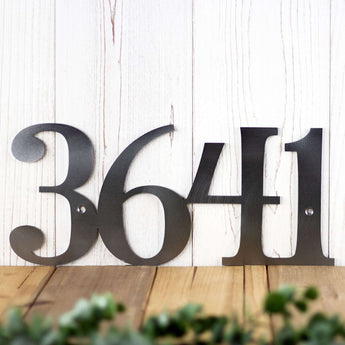 Close up of 4 digit metal address sign, in raw steel. 