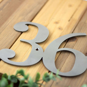 Close up of raw steel on our metal house number sign.