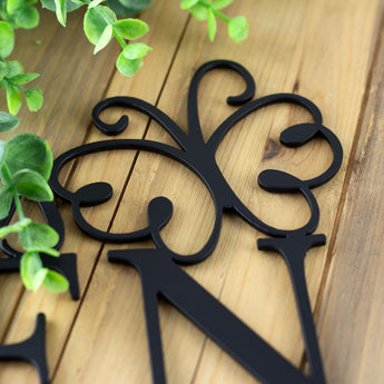 Close up of matte black powder coat on our metal garden name sign with a butterfly.