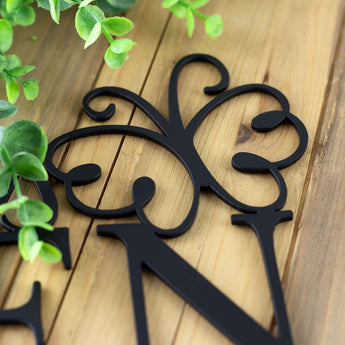 Close up of matte black powder coat on our metal garden name sign with a butterfly.