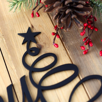Close up of matte black powder coat on our Happy Holidays metal wall art. 