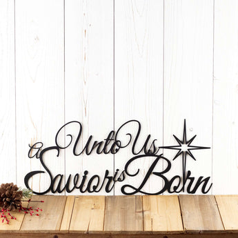 Unto us a Savior Is Born script metal wall art, with a Christmas star, in matte black powder coat.