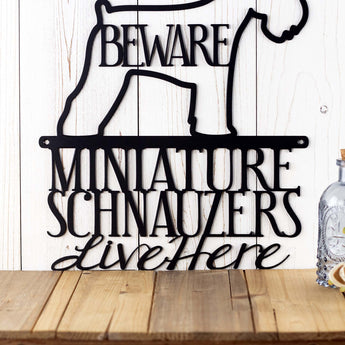 Close up of Miniature Schnauzers Live Here wording on our metal sign, in matte black powder coat. 
