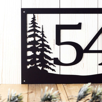 Close up of pine trees on our metal house number sign, in matte black powder coat. 