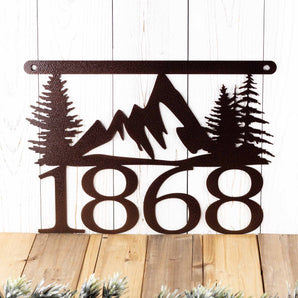Close up of 4 digit house number on our hanging metal address sign with mountains and pine trees, in copper vein powder coat. 