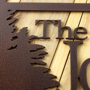 Close up of copper vein powder coat on the rectangular metal family name sign.