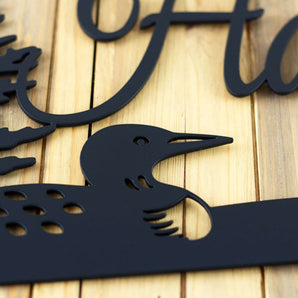 Close up of loon silhouette on our personalized family name metal sign, in matte black powder coat. 